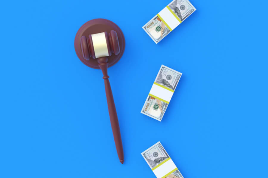 Judge's gavel and three piles of cash on blue background representing SSD attorney fees
